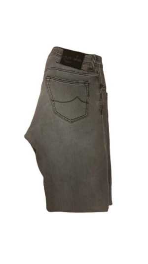 Grå jeans från Jacob Cohën Style 688 - Snygga grå jeans från Jacob Cohën, modell Style 688. Klassisk femficksdesign, slim ben och knappgylf. Jeansen har diskreta slitningar och är tillverkade i mjukt bomullstyg med en hint av stretch för extra komfort.