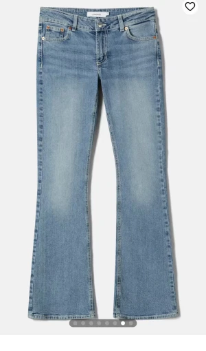 Ljusblå bootcut jeans från Junkyard - Snygga ljusblå jeans från Junkyard med klassisk femficksdesign och bootcut-ben. Jeansen har låg midja och är tillverkade i mjukt denimtyg som ger en avslappnad vibe. Perfekta för dig som gillar retrostil och vill ha ett par jeans med lite utsvängda ben. S/xs