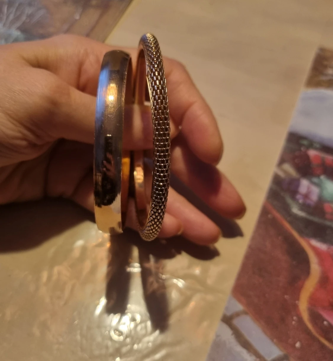 Två guldiga armband i metall