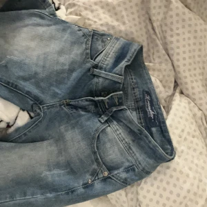 Ljusblå jeans från Dr. Denim - Säljer ett par ljusblå jeans från Dr. Denim med klassisk femficksdesign och smal passform. Jeansen har en snygg tvätt och är klippta från knät ner så perfekt om du vill själv sy dom till bootcut