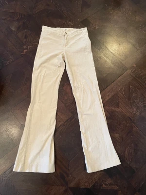 Beige bootcut-byxor från Yerse, M - Snygga beige bootcut-byxor från Yerse i mjukt bomullsmaterial, tunn bomullssammet. Byxorna har klassisk femficksdesign, knapp med Yerse-logga och raka ben med lätt utsvängd form. Perfekt för dig som gillar en clean och stilren look.