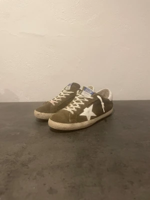 Golden Goose Olivgröna - Säljer dessa Golden Goose, ganska bra skick 8/10. Storlek 41, box finns tyvär inte kvar. En ganska sälsynt färg och 100% äkta. 1999 eller bud, skriv om ni har några frågor eller funderingar!👌
