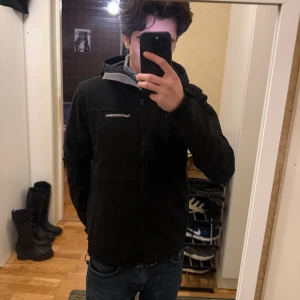 Peak Performance Goretex skidjacka  - Svart fodrad goretex regn/vind jacka från Peak Performance med huva och hel dragkedja framtill. Jackan har stilren design, diskret logga på bröstet och är tillverkad i syntetmaterial med mjukt fleecefoder på insidan.