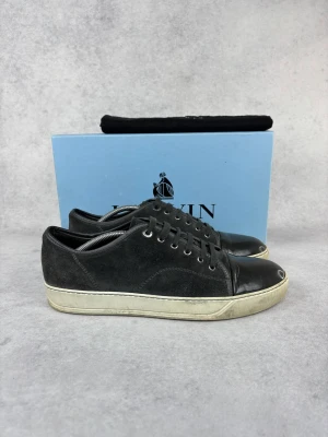 Lanvin DBB1 cap toe sneaker - – Condition: 8/10 - dirty  - Size: 44/UK10  – What is included: Only the sneakers  – Retail price: 5500 + SEK  Please note that Lanvins fit big and our recommendation is to go one size down