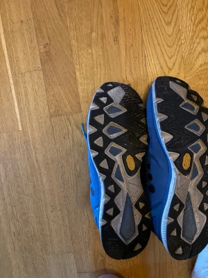 Blå löparskor med grov sula - Säljer ett par blå löparskor från Craft med ventilerande mesh-ovandel och grov Vibram-sula för extra grepp. Skorna har snörning och svarta prickdetaljer på sidan. Perfekt för dig som gillar att springa på varierat underlag.