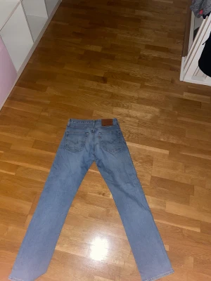 Levi's 501 ljusblå jeans straight fit - Säljer ett par klassiska Levi's 501 jeans i ljusblå tvätt med straight fit. De har fem fickor, knappgylf och det ikoniska bruna läderpatchen bak i midjan. Perfekt passform. Ej använda mycket väldigt gott skick.