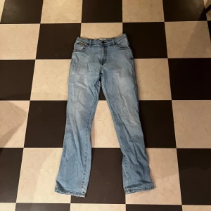 Wrangler Texas ljusblå jeans W29 L32 - Säljer ett par klassiska ljusblå Wrangler Texas jeans med raka ben och normal passform. Jeansen har fem fickor, snygga kontrastsömmar och läderpatch bak. Perfekt för dig som gillar tidlös denimstil.