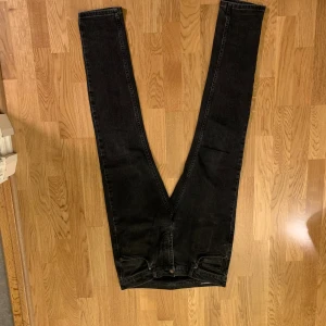 Svarta skinny jeans från J.Lindeberg - Svarta jeans från J.Lindeberg med klassisk femficksdesign och smal passform. Jeansen har en snygg, mörk tvätt och raka ben med skinny siluett. Materialet är jeans med detaljer i svart skinn på bakfickan. Perfekt för dig som gillar stilrena och moderna byxor.