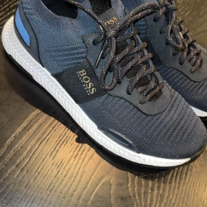 Mörkblå sneakers från Hugo Boss - Snygga mörkblå sneakers från Hugo Boss Stora i storlek, passar 42. Nypris 2399kr