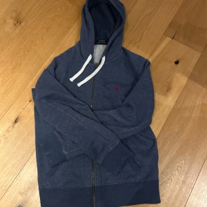 Blå hoodie från Polo Ralph Lauren - Snygg marinblå hoodie från Polo Ralph Lauren med röd broderad logga