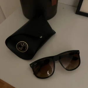 Svarta Ray ban boyfriend  solglasögon - Snygga svarta Ray-Ban boyfriend solglasögon med klassisk fyrkantig form och tonade bruna linser. Modellen är RB4147 och kommer med original svart fodral. Perfekt för dig som vill ha en ikonisk look och skydda ögonen mot solen.