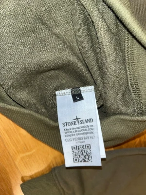 Olivgrön Stone Island sweatshirt L - Snygg olivgrön sweatshirt från Stone Island i storlek L. Tröjan har rund hals, ribbade muddar och den klassiska Stone Island-loggan på vänster ärm. Materialet är mjuk bomull och passformen är normal. Perfekt för dig som gillar streetwear och vill ha en clean look.