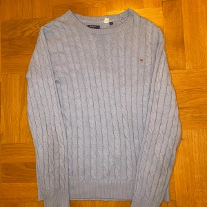 Ljusblå kabelstickad tröja från GANT - Snygg ljusblå kabelstickad tröja från GANT i storlek M. Den är jätte skön passar perfekt nu till vintern och har en snygg färg, nypris kostar den 1799 men säljer den för bara 399! Eftersom den är för lite på mig pris går att diskuteras vid snabb äffar. 