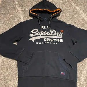 Superdry hoodie mörkblå - Mörkblå Superdry hoodie med riktigt snyggt tryck väldigt bra skick storlek xs bara att skriva om det är något 