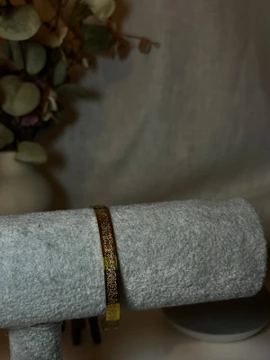 Guld armband med Ayatal-Kursi på - Ett armband som har ayatal kursi ingraverat.