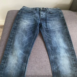 Mörkblå Lee Austin jeans W32 L32 - Säljer ett par mörkblå Lee Austin jeans med snygg tvätt och klassisk femficksdesign. Jeansen har raka ben och normal passform, tillverkade i slitstarkt bomullstyg. Perfekta för dig som gillar en tidlös look med lite faded detaljer.