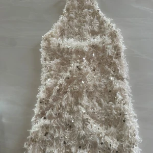 Champagnefärgad paljettklänning - Fin klänning champagnefärg med fluffig textur och glittriga paljetter över hela ytan. Aldrig använt, storlek S