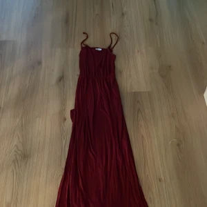 Vinröd långklänning från H&M XS - Säljer en vinröd långklänning från H&M i storlek XS. Klänningen har tunna axelband och har slitt på båda sidorna. Knappt använd men superfin klänning och hör av er om ni har några frågor💕