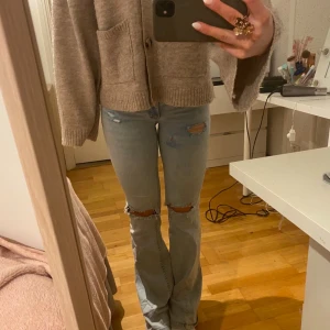  ljusa bootcut jeans med hål - Säljer ett par ljusblå jeans med hål från nelly i storlek 34/36💕
