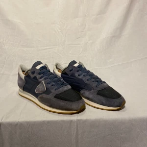 Philippe Model TRPX - Navyblå trainers från Philip Modell i storlek 45 men funkar för 44. Skorna har fina mockadetaljer och snörning. Skorna är använda några gånger men det finns knappast några märken av tidigare användning på mockat.  Perfekta för en avslappnad stil, men funkar också helt perfekt om du vill känna dig lite mer uppklädd. Om du undrar något om skorna är det bara att fråga på, svara så snabbt jag kan😁🙌