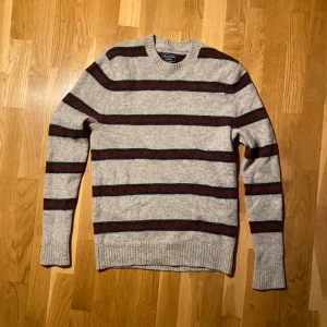 Abercrombie & Fitch tröja - Snygg stickad tröja från Abercrombie & Fitch i grått med breda mörkröda och mörkgröna ränder. Den passar storlek S men också XS. Inga tecken på slitage. 100% ull. Ifall mer frågor, ställ gärna!