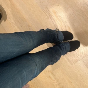 Blå lågmidjade bootcut jeans True Religion - Säljer ett par blå jeans från True Religion med låg midja och bootcut-ben. Dom är uppsydda från skinny men sitter jättebra. Kan sänka priset
