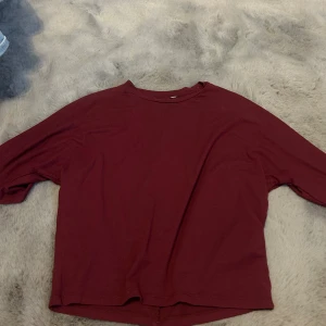 Vinröd tröja - En enkel och stilren vinröd tröja med rund hals. Tröjan har en loose passform och är tillverkad i mjukt bomullsmaterial, perfekt för att chilla eller hänga med kompisar. Passar dig som gillar basic och bekväma plagg.
