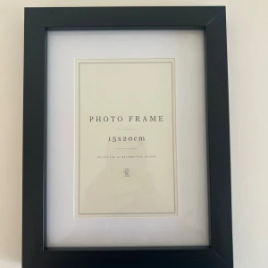 Fotoram 15x20 - Svart fotoram med måtten 15x20 cm. Ramen har ett stöd på baksidan för att kunna stå på en plan yta. Helt oanvänd!