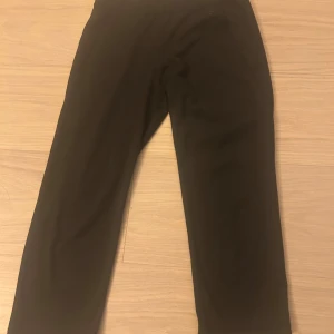 Svarta sportleggings från H&M - Svarta sportleggings från H&M Sport i storlek S. De har en smal passform och är tillverkade i ett stretchigt syntetmaterial som är perfekt för träning. Midjan är elastisk och byxorna har en enkel, stilren design utan synliga detaljer.