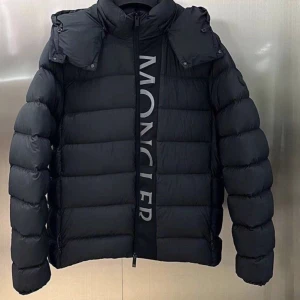 Svart pufferjacka från Moncler - Säljer en svart pufferjacka från Moncler med stor logotyp längs dragkedjan. Jackan har hög krage, avtagbar huva och breda, quiltade sektioner som ger en riktigt fet look. Perfekt för kalla dagar och har en modern, oversized passform.