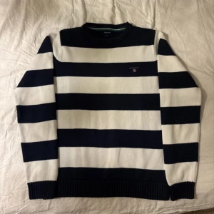 Randig stickad tröja från GANT - Snygg stickad tröja från GANT med breda marinblå och vita ränder. Den sitter pyttelite tight för att vara storleken S, men har i övrigt en mycket fin passform. Hör gärna av er vid frågor eller om ni vill ge prisförslag.