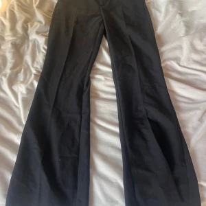 Svarta vida kostymbyxor - Snygga svarta kostymbyxor med vida ben och klassisk passform. Perfekta för en stilren look och passar till både sneakers och boots. Materialet känns mjukt och har en lätt stretch för extra komfort. Samma som dom andra jag lagt upp, bara annan storlek.
