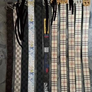Designer bälten med rutor och logga - Säljer flera snygga bälten från Louis Vuitton och Burberry. Bältena har klassiska rutiga och monogrammönster i färger som svart, beige, vit och grå. De har stilrena metallspännen och är tillverkade i skinn med tryckt mönster. Perfekt för dig som vill ha en statement-accessoar.200 kr styck