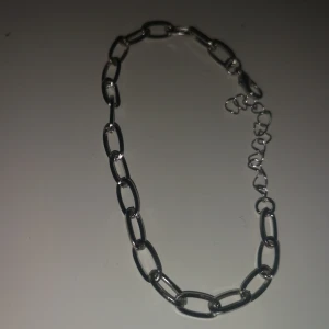 Silvrigt armband med stora länkar - Stilrent armband i silverfärgad metall med stora, ovala länkar och justerbar kedja med karbinlås. Perfekt för dig som gillar chunky smycken och vill ha en modern touch på din look.