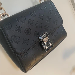 Svart axelväska från Guess  - Svart axelväska från guess i bra skick
