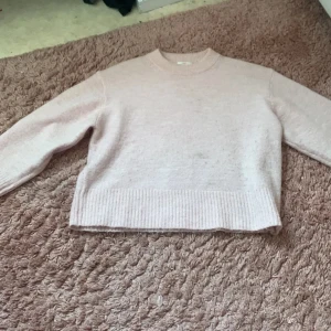 Ljusrosa stickad tröja Gina Tricot - Supermjuk ljusrosa stickad tröja från Gina Tricot med rund halsringning och breda ribbade muddar vid ärmslut och nederkant. Perfekt för lager på lager och chill dagar. Enkel och stilren design som är lätt att matcha.