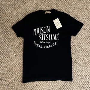 Maison kitsuné t-shirt - Säljer nu denna eftertraktade Maison kitsuné t shirten då den tyvärr är för liten. Strl Xs och 10/10 skick då den endast är använd en gång. Köpt ny och lapp tillkomer!😁