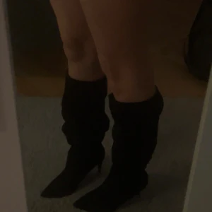 Svarta stövlar med klack och spetsig tå - Säljer ett par svarta stövlar med klack och spetsig tå, dom har inte kommit till mycket användning därav säljer jag. Stövlarna är i tyg så man kan ändra längden på benen hur man vill ha det, pris kan diskuteras🤍