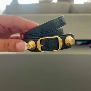 Balenciaga armband med guld detaljer  - Trendig och efter frågad Balenciaga armband i guld detaljer i gråaktigt läder. Pris går att diskutera!💕