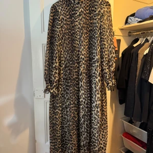 Leopardmönstrad långklänning från Ganni - Säljer en maxiklänning från Ganni med leopardmönster i svart och beige. Klänningen har lång ärm, plisserad. 