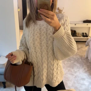 Stickad  tröja från Zara - Säljer en krämvit, stickad tröja från Zara med ”grovt” flätmönster. Jättemysig nu till vintern eller när man bara är hemma. Säljer då den inte kommer till användning. Kom privat för frågor eller fler bilder  