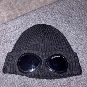 Svart C.P. Company mössa  - Svart ribbstickad mössa från C.P. Company, Jag säljer nu min C.P Company mössa, den är äkta inköpt för 1600, den är använd runt kanske 13 gånger för att jag inte tyckte om den och passa inte i den… den är ju som sagt  äkta och Unisex, den är dessutom One zize. Men om du är intresserad tveka inte att höra av dig, köparen betalt frakt och priset kan diskuteras!! 