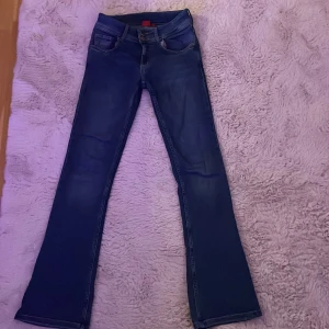 Snygga mörkblåa bootcut jeans - Jag säljer mina jeans  på grund av lite användning, mid/low waist med utsvängd byxa. Jeansen har stjärnor på knappar fram och bak med snygga fickor, passar till allt och har en stilren passform. I storlek 170, Pris kan diskuteras! Om det går välj helst instabox eller postnord, 💗