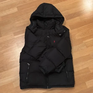 Svart pufferjacka från Polo Ralph Lauren - Svart pufferjacka från Polo Ralph Lauren. Storlek: xl (18-20), barnstorlek. Passar xxs eller längd 165 - 170. Finns två defekter (bild 3 och 4). Skriv om ni har några funderingar!