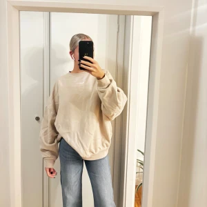 Beige oversized sweatshirt från Nike - Säljer en beige oversized sweatshirt från Nike med klassisk logga framtill. Tröjan har rund hals, långa ärmar och ribbade muddar. 