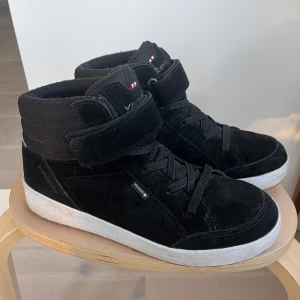 Svarta Viking Eagle Warm GTX sneakers, st 40 - Svarta mellanhöga Eagle Warm GTX (junior) – varma, lätta och helt vattentäta vintersneakers i mocka med Gore-Tex och fleecefoder. Enkla att ta på med elastiska snören + kardborre. Endast använda några månader innan de blev urvuxna. Nypris 1350 kr. Finns i Sollentuna, kan skickas.