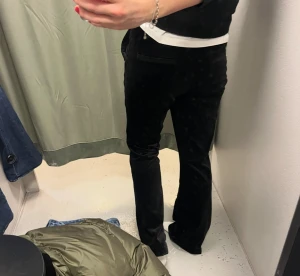 Svarta manchesterbyxor med bootcut - Snygga svarta manchesterbyxor med bootcut-snitt och hög midja. Byxorna har en klassisk look med mjukt material och raka ben som blir lite vidare nedtill. Perfekta för dig som gillar retrovibbar och vill ha något som sticker ut.