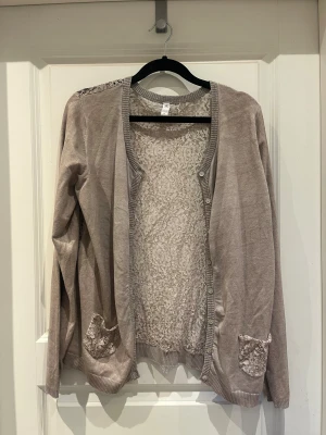 unik kofta med blommigt spetsmönster - säljer denna jättefina unika kofta med blommigt spetsmönster och glittriga detaljer. storlek XS men skulle säga att den snarare är S 🥰