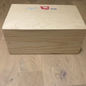 Trälåda för sminkförvaring - Snygg och stilren trälåda i ljus träfärg, perfekt för att förvara smink och beautyprylar. Lådan har ett enkelt lock med gångjärn och är rymlig inuti, så du får plats med allt från borstar till paletter. Passar dig som vill ha ordning på sminket och gillar naturliga material.