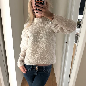 Beige blus med öppen rygg från H&M - Säljer en beige blus från H&M i storlek 34/XS. Blusen har ett krinklat tyg, lång ärm och en snygg öppen rygg. Tillverkad i 100% polyester och har en lätt puffig axel för extra stilpoäng.